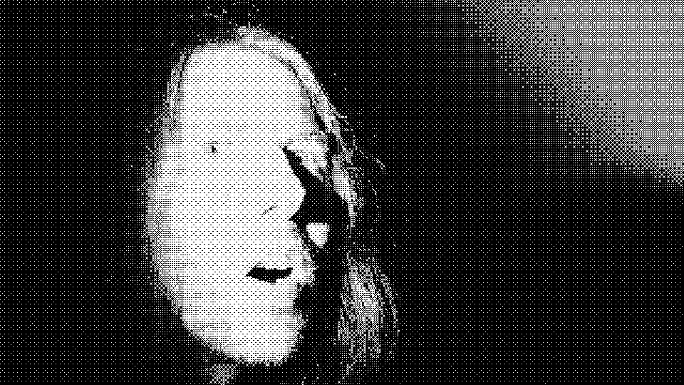 A face lit from one side staring past the camera, mouth open, in harsh black and white