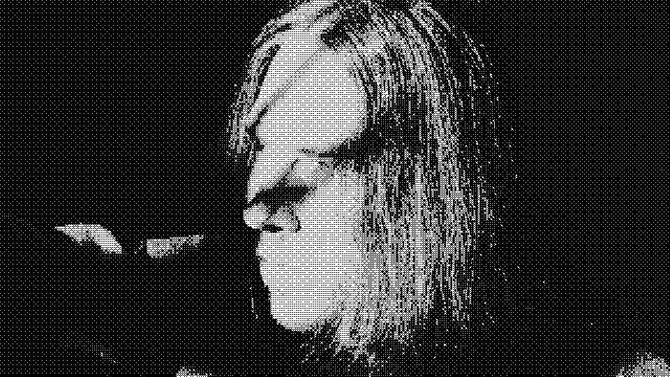 A profile view of a figure with hair covering the face, in harsh black and white