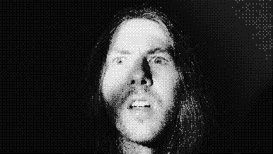 A wide-eyed face staring directly into the camera, in harsh black and white